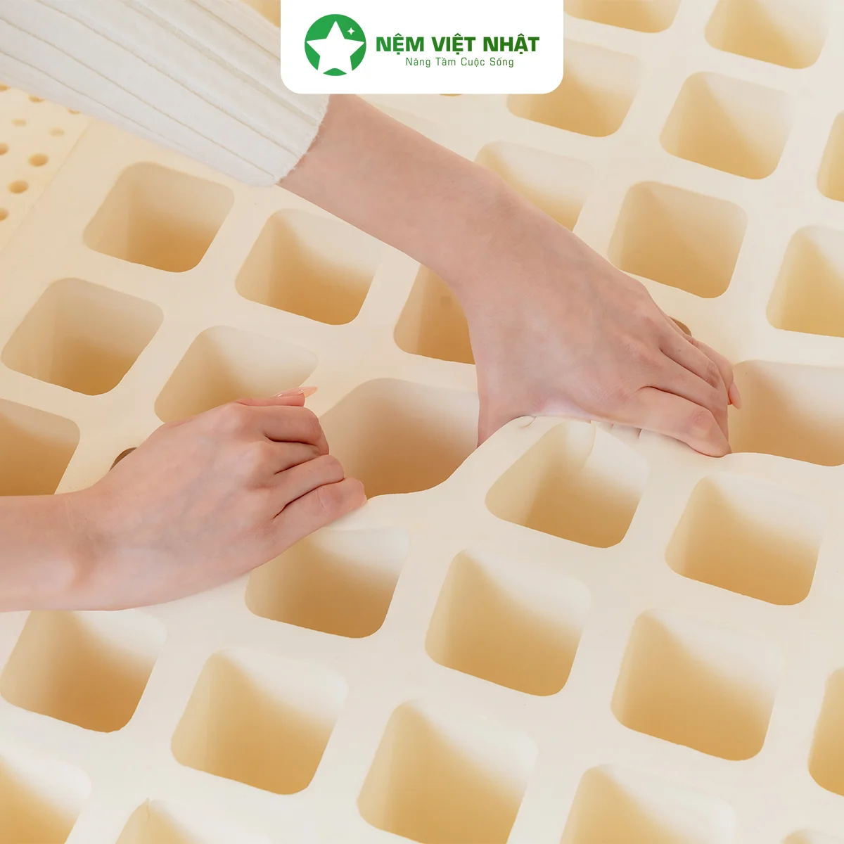 Hai tay kéo giãn ruột nệm cao su thiên nhiên Natural, lộ hệ lỗ thoáng khí vuông bên dưới